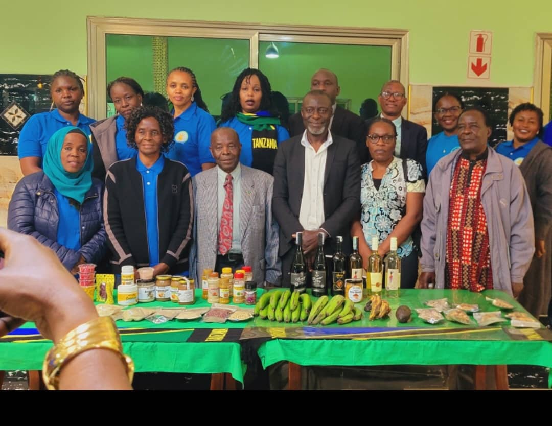 Members and partners standing behind a display of locally produced foods and beverages.