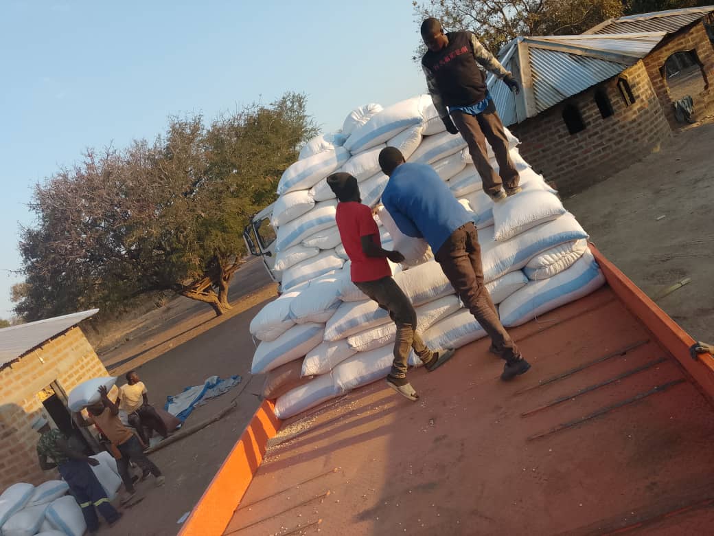 Workers stack bags of maize onto a waiting truck at the Chisalu Depot.